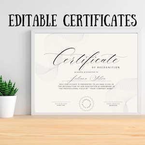 Op de afbeelding: Een ingelijst certificaat met de tekst "EDITABLE CERTIFICATES" bovenaan. Het certificaat is gebroken wit met een vloeiend ontwerp en de tekst "Certificate of Recognition". Het bevat ruimte voor een naam en bedrijfsgegevens.