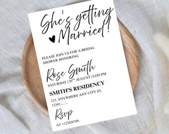 May include: A white invitation card with black text announcing a bridal shower, with the words "She's getting Married!". The card is on a wooden plate, with the text "Editable Invitation" and "ViralInvites" at the top and bottom.