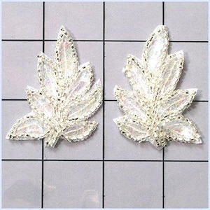 May include: Two iridescent leaf-shaped appliques. Each leaf has a delicate, lacy appearance with a shimmering, pearlescent finish. The edges are outlined with small, silver beads. These decorative embellishments are ideal for adding a touch of elegance to craft projects.