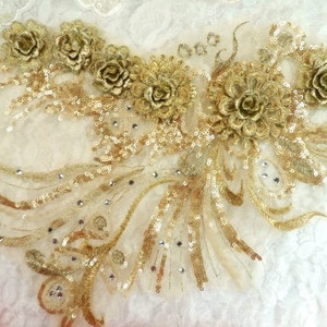 Peut inclure: Applique dorée à sequins et brodée avec des motifs floraux. L'applique est sur un tissu blanc transparent.