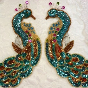May include: Two peacock-shaped sequined appliques in teal, gold, and iridescent colors. The appliques are perfect for adding a touch of sparkle to clothing, bags, or home decor projects.