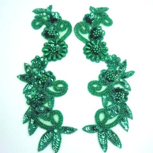 May include: Two green beaded and sequined floral appliques. Each applique features a large flower with smaller flowers and leaves.