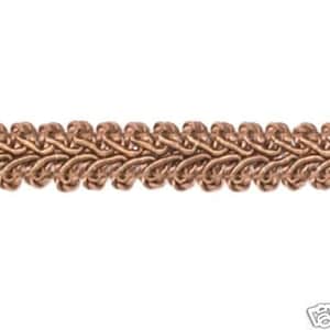 May include: A close-up of a braided trim with a woven design. The trim is a light brown colour.