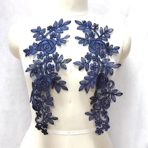 May include: Two blue floral lace appliques with a delicate design featuring roses and leaves. These appliques are perfect for adding a touch of elegance to any garment or craft project.