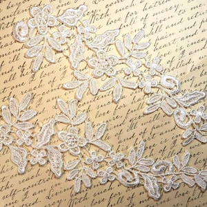 May include: White lace trim with a floral design. The lace is delicate and intricate, with small flowers and leaves.