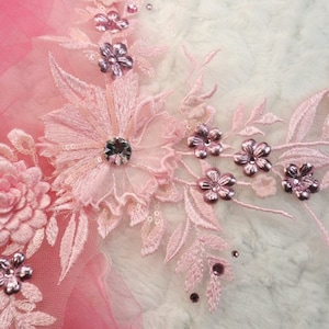 Peut inclure: Applique en dentelle florale rose avec des perles et des strass. L'applique présente des motifs floraux délicats et des détails complexes.