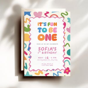 May include: A vibrant birthday invitation with the words "IT'S FUN TO BE ONE" in bold lettering. The invitation announces "SOFIA'S 1st BIRTHDAY" and the date "MAY - 16 - 3 PM". The design incorporates colourful shapes and a decorative border.