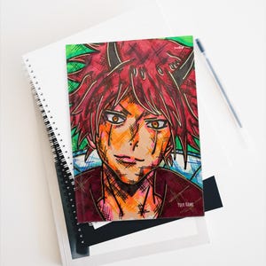 Puede incluir: Un cuaderno con espiral que presenta una colorida ilustración de estilo anime de un personaje con cabello rojo y piel naranja. La obra de arte está detallada con sombreado cruzado y líneas audaces. Un bolígrafo descansa junto al cuaderno sobre una superficie blanca.