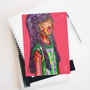 Op de afbeelding: Een spiraalgebonden notitieboek met een levendige, veelkleurige grafische illustratie van een personage met lang donker haar en een open mond tegen een effen roze achtergrond. De kaft bevat de tekst "YOUR NAME" in de rechterbenedenhoek.