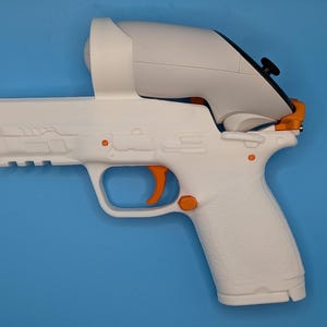 May include: A white and orange VR gun controller, designed to hold a VR controller. The controller has an orange trigger and accents, with a white body. The background is a solid blue.
