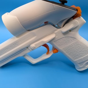May include: White and orange Grip Daddy accessory for a gaming controller, with the text "GRIP DADDY" on the side. The accessory is set against a blue background.