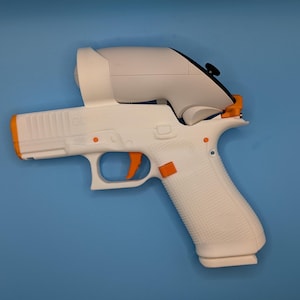 May include: A white and orange toy gun with a white scope attachment. The toy gun has an orange trigger and accents. The grip has a textured pattern. The background is a solid blue.
