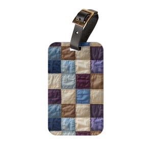 Può includere: Un'etichetta per bagagli rettangolare con un design patchwork nei toni del blu, viola, marrone e crema. Ha un cinturino in pelle nera con una fibbia color oro.