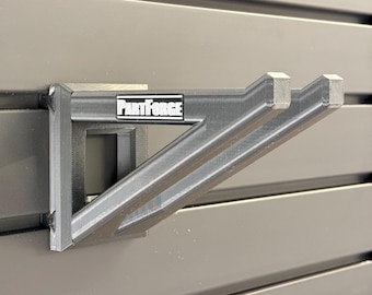 Uniwersalny uchwyt ścienny do urządzeń na wysięgniku (podkaszarki żyłkowej, krawędziarki, głowic wielofunkcyjnych i innych).