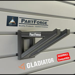 May include: A dark gray bracket with the text "PARTFORGE" and "Quality Products - Custom Creations". The bracket is mounted on a light gray wall with the text "GLADIATOR" and "GEARWALL Compatible".