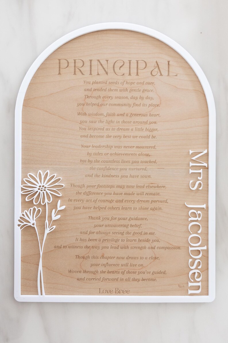 Puede incluir: Una placa de madera arqueada con un marco blanco que presenta el texto PRINCIPAL, un poema y el nombre Mrs Jacobsen. Un recorte floral blanco est&aacute; unido al lado izquierdo. El poema comienza con You planted seeds of hope and care y termina con Love Bree.
