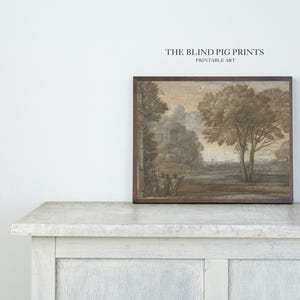 May include: A printable art print depicting a landscape scene with a building in the distance, trees, and figures in the foreground. The print is framed in a brown wood frame and features the text "THE BLIND PIG PRINTS PRINTABLE ART" at the top.