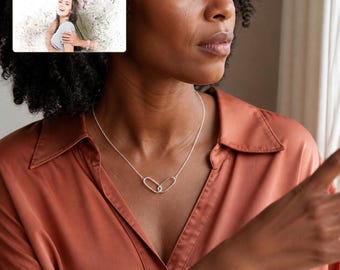 May include: A silver-toned necklace featuring two interlocking oval links as a pendant. In the upper left corner, a rectangular insert displays a photograph of a couple with the text "forever with you" and "OLIVIA & ADAM" printed above.