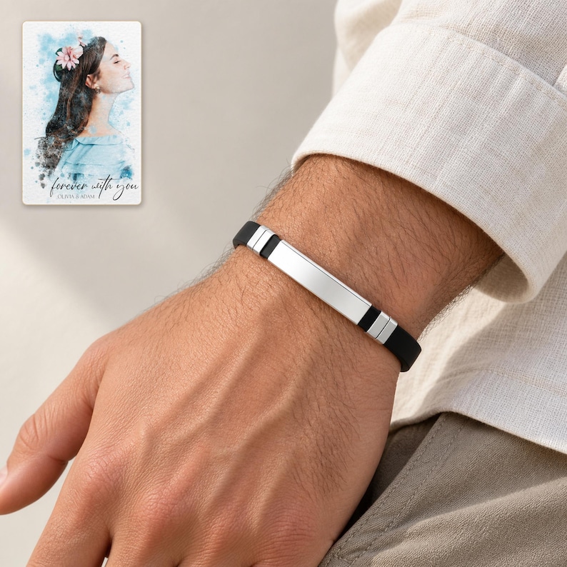 Adult man wearing the black strap and silver-tone bar bracelet beside a cream shirt cuff. A personalized digital greeting card is shown alongside.