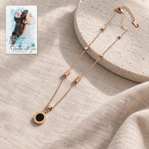 Roman Numeral Necklace, linen flatlay view. A personalized digital greeting card is shown alongside.