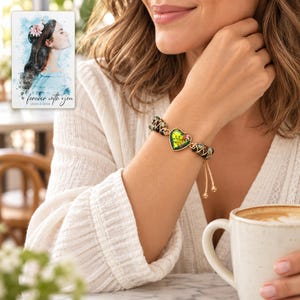 Verdant Heart Woven Bracelet worn by an adult in a natural daytime lifestyle scene. A personalized digital greeting card is shown alongside.
