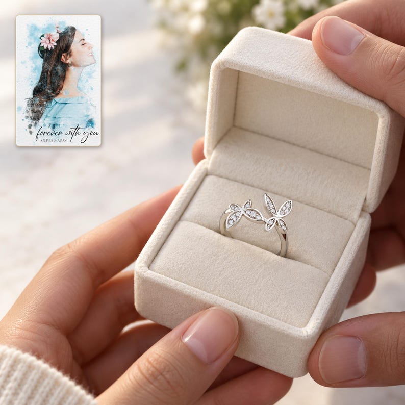 Two adults passing an open ivory box containing the double butterfly silver-tone ring. A personalized digital greeting card is shown alongside.