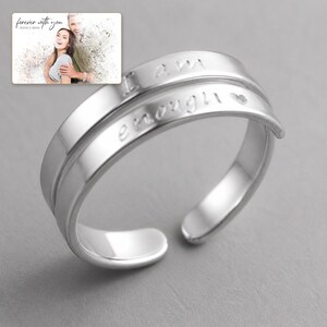 Brave Word Open Band Ring shown during a warm gift-receiving moment between adults with the exact jewelry visible.