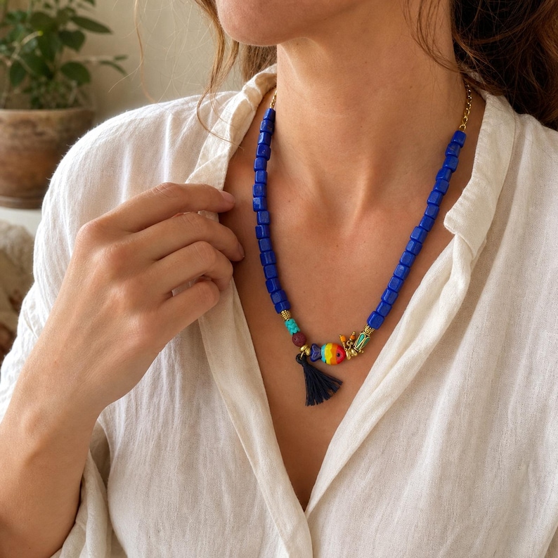 Blue and Clear Statement Beaded Necklace presented in an open jewelry gift box on natural linen