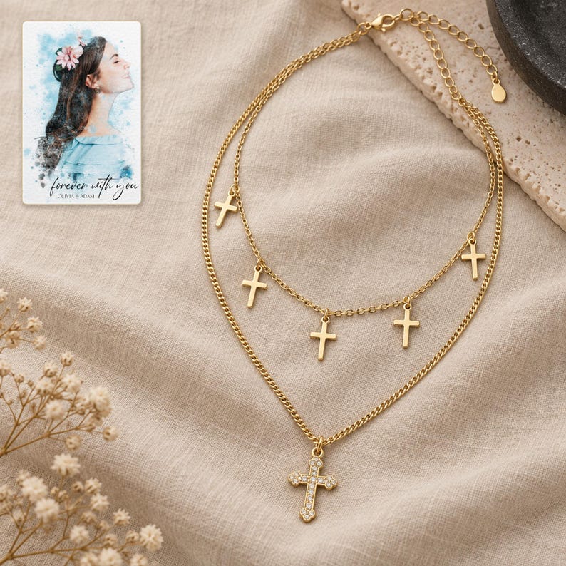 Golden Faith Layered Cross Necklace arranged on soft ivory linen in a refined neutral flat lay. A personalized digital greeting card is shown alongside.