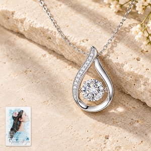 Moissanite Teardrop Necklace, shown on a display surface. A sample personalized digital greeting card is shown alongside.
