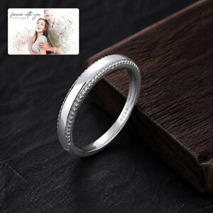 May include: A silver-colored ring with a smooth, polished center band flanked by two rows of small, textured, pyramid-shaped studs. The interior of the band is clearly stamped with the text S925, indicating the metal composition of the ring.