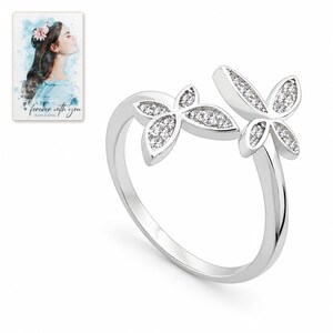 White-background catalog view of the silver-tone ring with two butterflies at the open bypass front. A personalized digital greeting card is shown alongside.