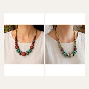 May include: Two necklaces featuring round beads in varying sizes and textures. The left necklace has red and turquoise beads with metallic spacers. The right necklace features muted green, brown, and turquoise beads with metallic spacers on a gold chain.