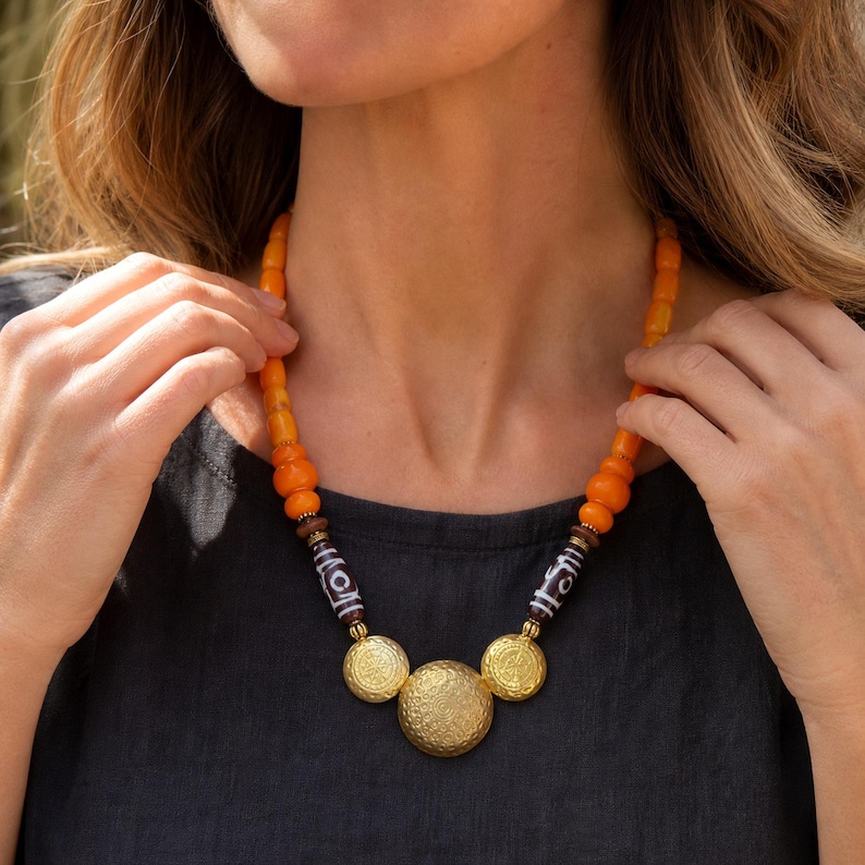 Three-piece handmade necklace set featuring orange and beige beaded necklace, orange and brown beaded necklace and orange and brown beaded necklace, displayed together to show the coordinated colors and beadwork