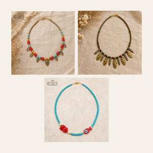 May include: Three necklaces are displayed. The first features red, yellow, and turquoise beads with gold-tone leaf charms. The second has green, red, and gold beads with elongated gold-tone pendants. The third has turquoise beads, red accents, and a fish charm.