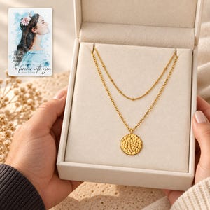 Gold Tone Coin Satellite Necklace shown during a warm gift-receiving moment between adults with the jewelry visible. A personalized digital greeting card is shown alongside.