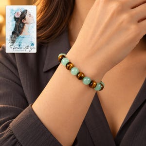 Forest Amber Bead Bracelet worn by an adult in a polished evening lifestyle scene. A personalized digital greeting card is shown alongside.