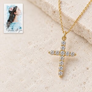 Macro of the eleven clear stone style in the gold-tone upright cross, with two above center and four below. A personalized digital greeting card is shown alongside.