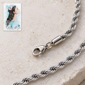 Macro view of fine twisted rope links, cylindrical end cap and matching lobster clasp. A personalized digital greeting card is shown alongside.