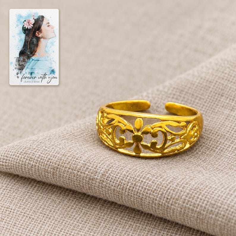 Golden Bloom Filigree Ring arranged on soft ivory linen in a refined neutral flat lay. A personalized digital greeting card is shown alongside.