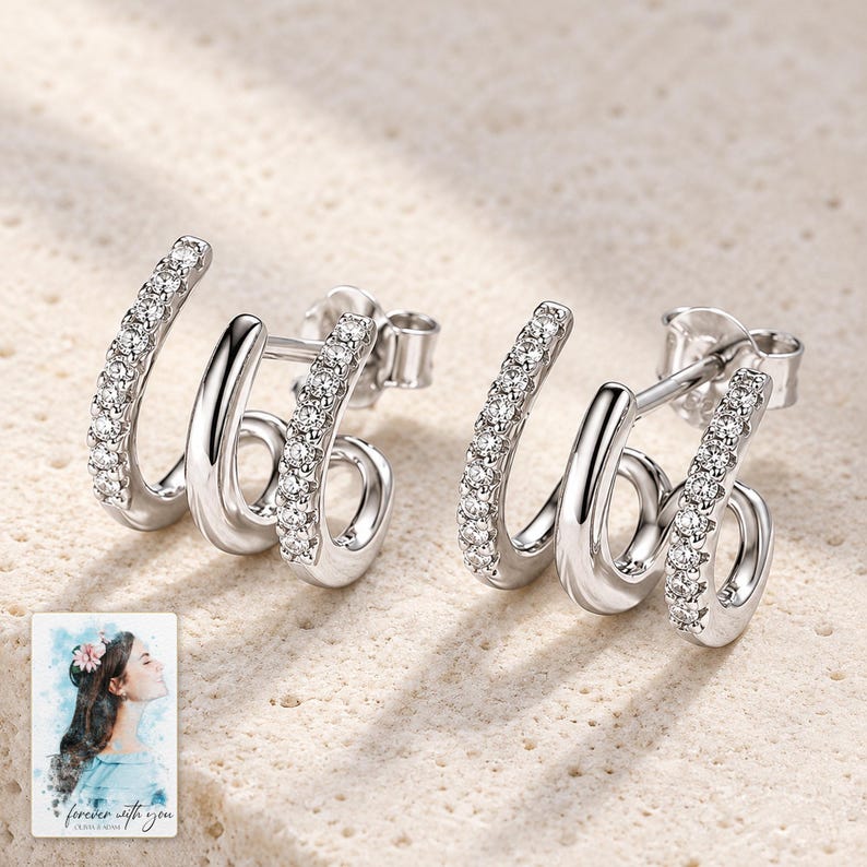 Triple Arc Stud Earrings, shown on a display surface. A sample personalized digital greeting card is shown alongside.