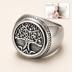 Silver-tone ring with a round tree motif, display view. A personalized greeting-card example appears in the corner.