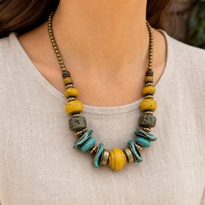 Rose Gold and Gray Statement Beaded Necklace presented in an open jewelry gift box on natural linen