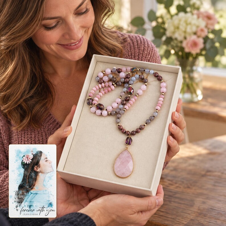 An adult receiving a gift box with the Pink option mixed-bead necklace and pale-pink teardrop pendant. A personalized digital greeting card is shown alongside.