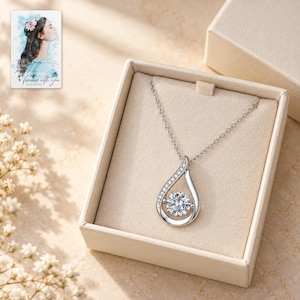 Moissanite Teardrop Necklace, displayed in a presentation box. A sample personalized digital greeting card is shown alongside.