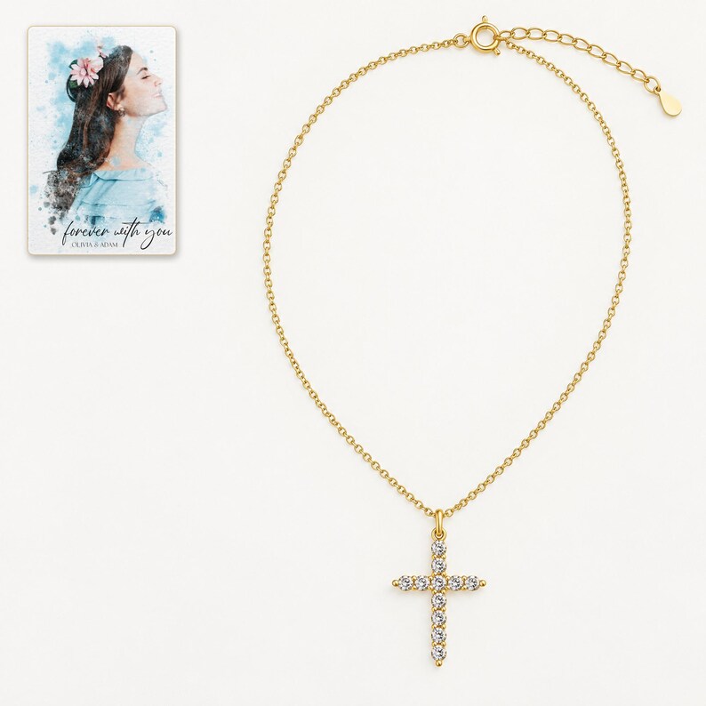 Golden cross necklace on clean ivory-white, showing the fine chain and clear round stone style in the upright pendant. A personalized digital greeting card is shown alongside.