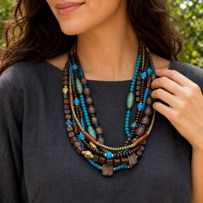 Three-piece handmade necklace set featuring blue and clear beaded necklace, beige and brown beaded necklace and rose gold and blue beaded necklace, displayed together to show the coordinated colors and beadwork