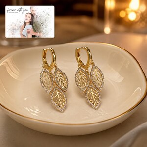 Gilded Leaf Cluster Clips arranged on soft ivory linen in a refined neutral flat lay.