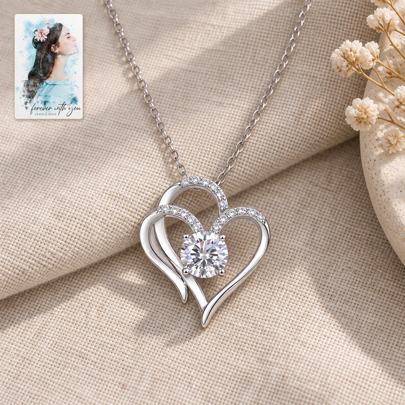 Double Heart Pendant Necklace, laid on fabric. A sample personalized digital greeting card is shown alongside.