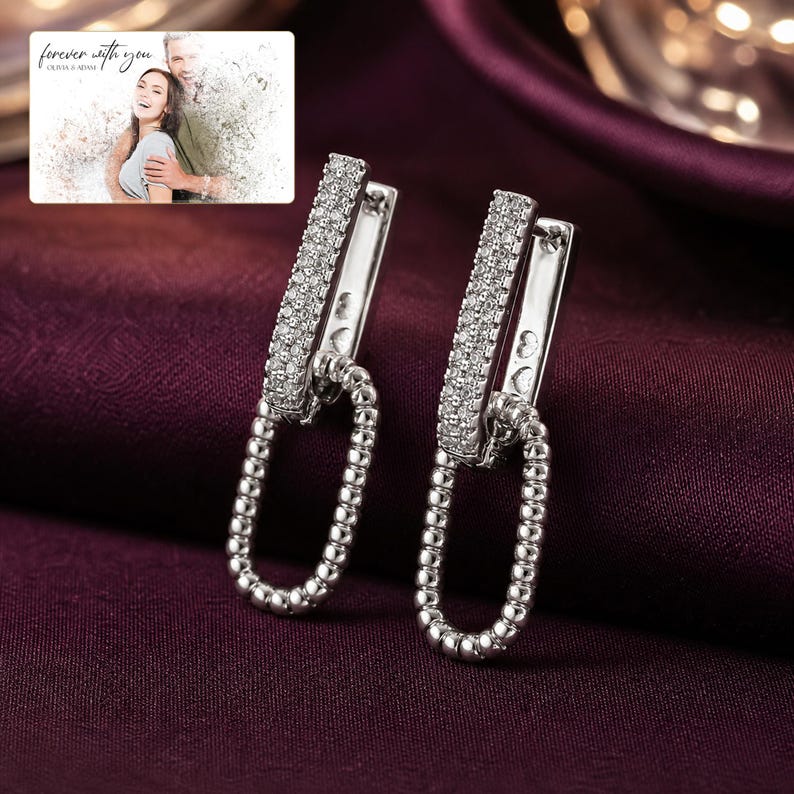 Silver Current Zircon Drops arranged on soft ivory linen in a refined neutral flat lay.
